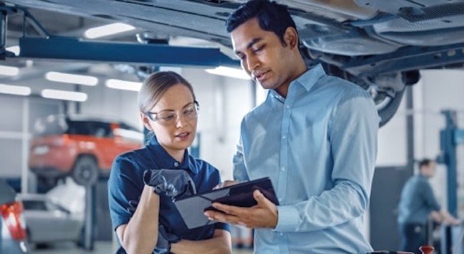 Mitarbeiter in der Automobilbranche besprechen Daten auf einem Tablet